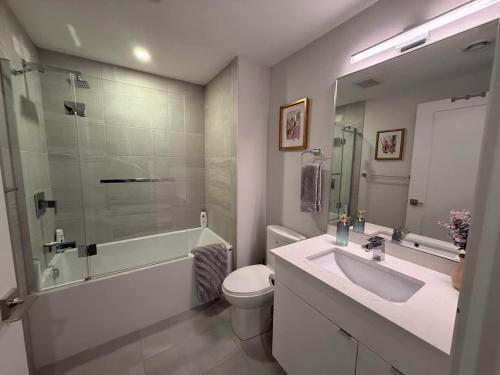 Un baño con lavabo, inodoro y ducha. en Spotless vibrant & modern 1 BR with 6 appliances, en Halifax