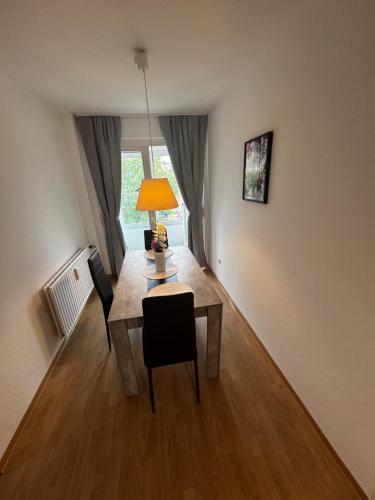 a room with a table with a lamp and chairs at Moderne Monteurwohnung in der Nähe vom VW Werk 1 in Wolfsburg