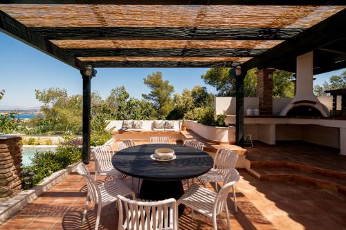 a patio with a table and chairs and a fireplace at Villa Calma by A&D Properties in Porto Rafti