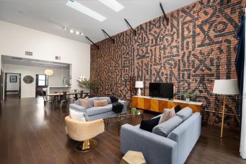a living room with two couches and a brick wall at Audemar Boutique Hotel and Apartment Homes in Los Angeles