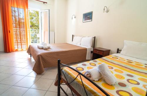 a bedroom with two beds and a baby laying on the bed at Hotel Kastri in Nea Mesangala
