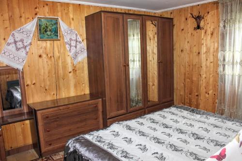 a bedroom with a bed and a wooden wall at Сільська садиба in Yablunytsya