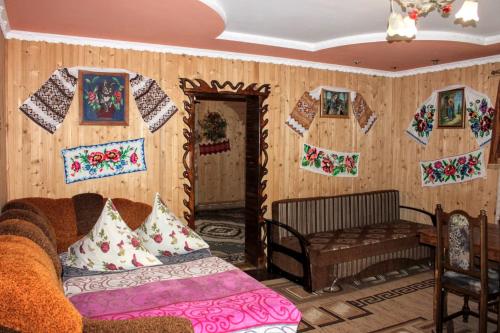 a living room with a couch and pictures on the wall at Сільська садиба in Yablunytsya