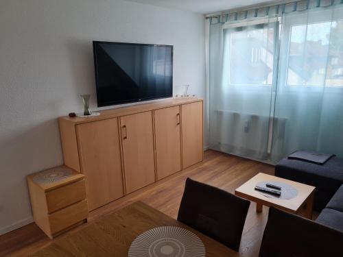een woonkamer met een flatscreen-tv op een kast bij Schöne Dachgeschoss Wohnung in Marl