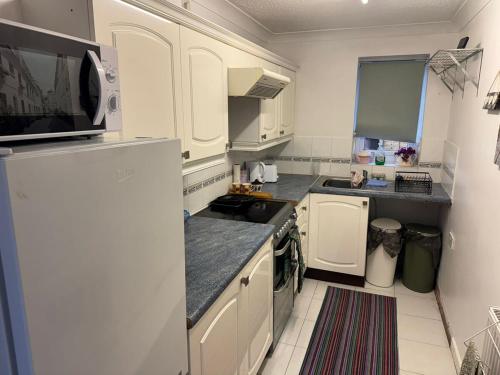 East HarlingにあるThe Wright Midweek stayの白いキャビネットと白い冷蔵庫のあるキッチン