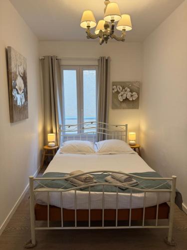 a bedroom with a bed with a view of the ocean at Fenêtres sur Mer Arromanches in Arromanches-les-Bains
