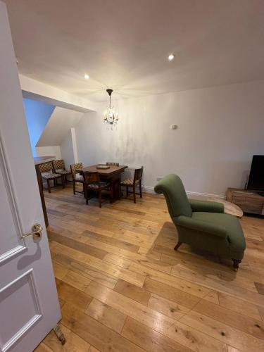 a living room with a green chair and a table at Gilberts Townhouse in Cobh