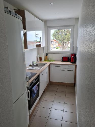 een kleine keuken met witte kasten en een raam bij Schöne Dachgeschoss Wohnung in Marl