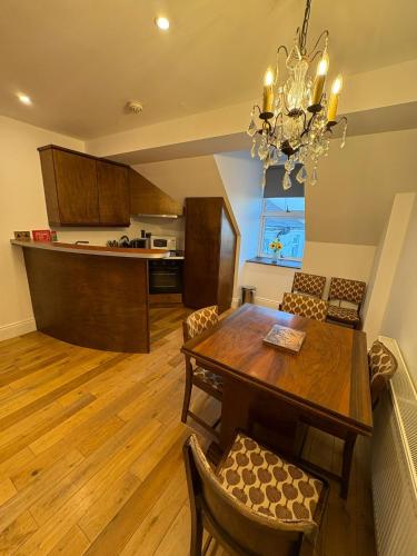 a kitchen and dining room with a wooden table and chairs at Gilberts Townhouse in Cobh