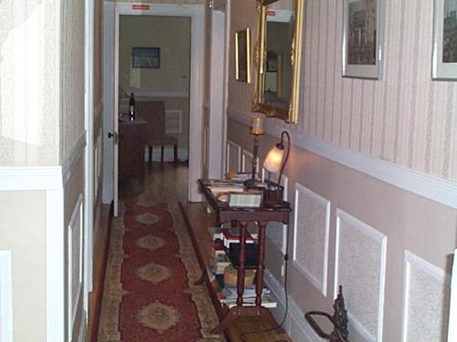 a hallway with a table with a lamp on it at B&B Le Transit in Quebec City