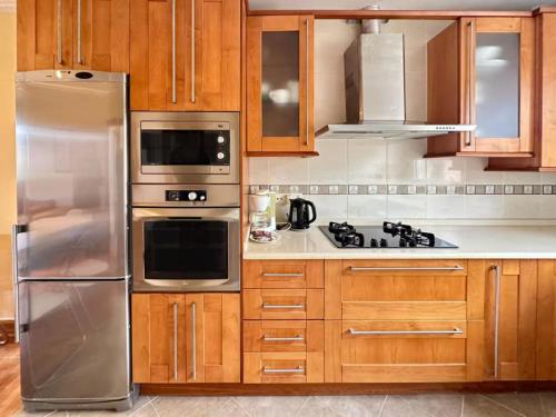 メリーデにあるCarmela Houseのキッチン(木製キャビネット、ステンレス製の冷蔵庫付)