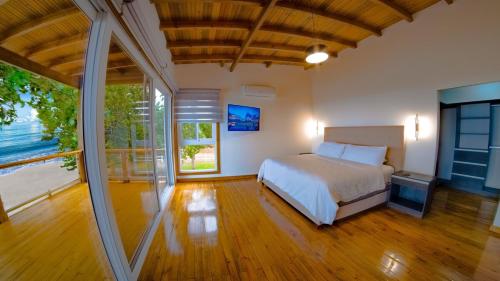 a bedroom with a bed and a large window at Casa Playa Almendro, Tela, Honduras 