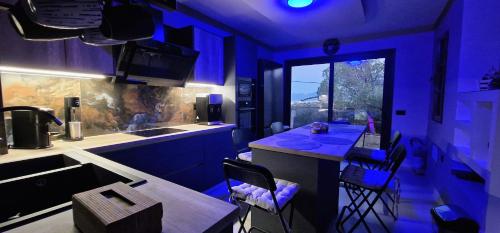 a kitchen with purple lighting and a counter with chairs at Cretan stars villas in Limín Khersonísou