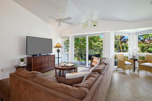 a living room with a couch and a flat screen tv at Villas of Kamalii #35 in Princeville