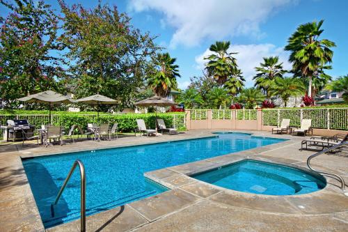 a swimming pool with chairs and umbrellas at Villas of Kamalii #35 in Princeville