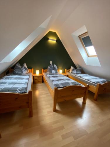 Cette chambre mansardée comprend 3 lits. dans l'établissement Ferienwohnungen Wiek, Haus Luv & Lee, à Wiek auf Rügen