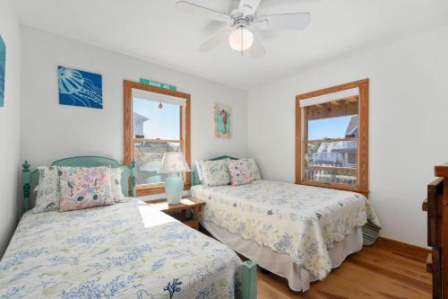 a bedroom with two beds and a ceiling fan at D124- Gillis in Sanderling