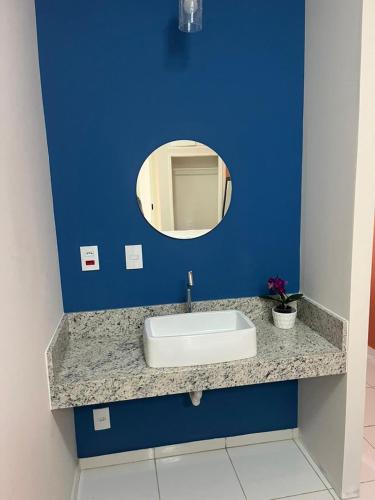 a bathroom with a sink and a mirror on a blue wall at Pousada Sete Colinas in Bragança Paulista