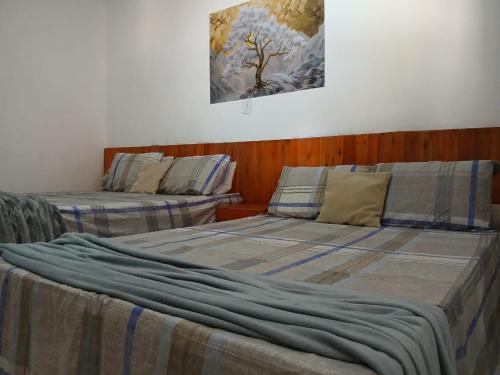 two beds sitting next to each other in a room at Casa confortável c piscina, lazer e espaço gourmet in Barra de São Miguel
