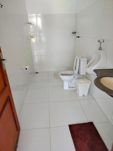 a white bathroom with two toilets and a sink at Casa confortável c piscina, lazer e espaço gourmet in Barra de São Miguel
