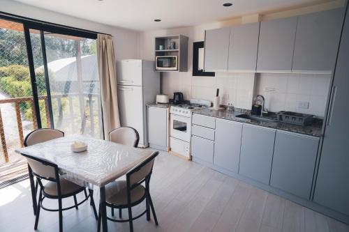 a kitchen with a table and a table and chairs at Check and home - Chapa II - 4 huéspedes con patio y parrilla in Chapadmalal