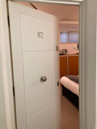 Una puerta con el número en un dormitorio en NELL GWYNN HOUSE - Hotel Style POD Room 62, en Londres