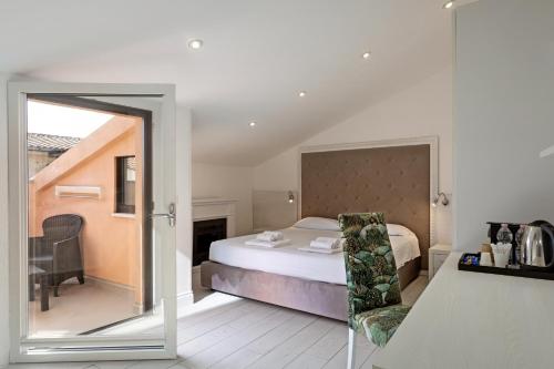 a bedroom with a bed and a chair and a mirror at Isola nel Parco Villas & Rooms in La Maddalena