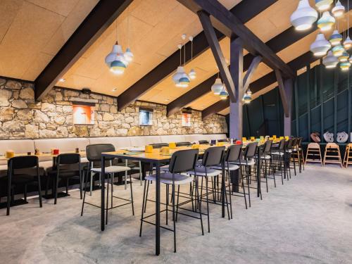 uma sala de jantar com uma mesa longa e cadeiras em La Cachette, Friendly Hotel & Spa em Arc 1600