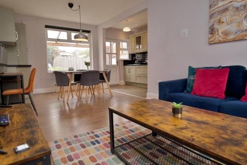 a living room with a blue couch and a table at London Road Villa - Free Netflix, Private Parking, WiFi & Private Garden in Coventry