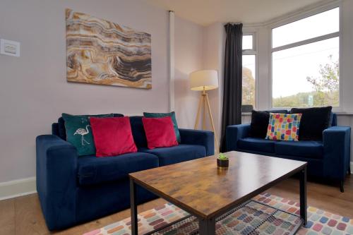a living room with two blue couches and a coffee table at Whitley House - Stylish 3 Bedroom Home near Coventry City Centre in Coventry