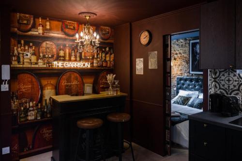 een bar met een bar en krukken in een kamer bij Le Garrison - l'univers des Peaky Blinders à Bergerac in Bergerac