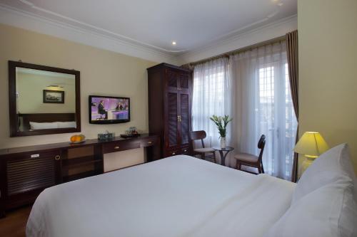 a bedroom with a large white bed and a mirror at Classic Street Hotel in Hanoi