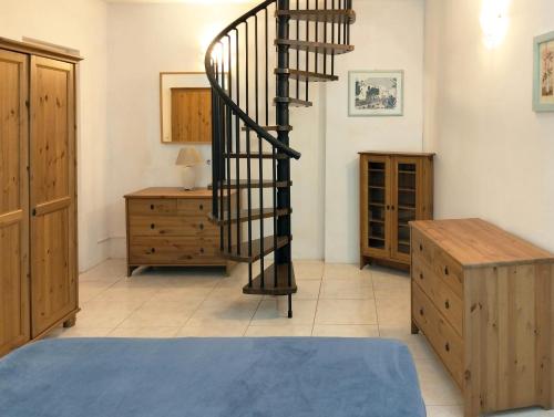 a living room with a spiral staircase and a dresser at Los Azahares Apartment in Costa Del Silencio