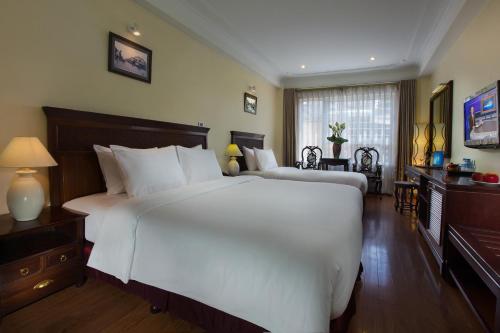 a bedroom with a large white bed and a desk at Classic Street Hotel in Hanoi