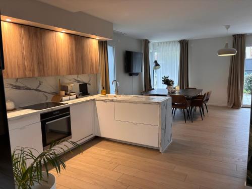 een keuken met witte kasten en een eetkamer bij Échappée Alsacienne in Illzach