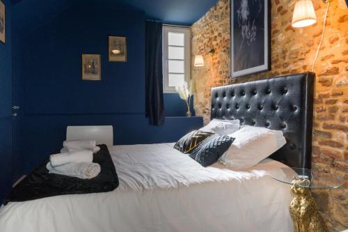 een slaapkamer met een bed met blauwe muren bij Le Garrison - l'univers des Peaky Blinders à Bergerac in Bergerac