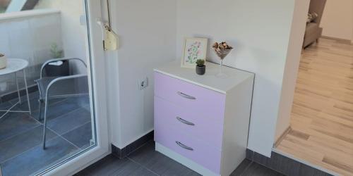 een witte dressoir met een plant erop bij Apartman Kovačić in Kutina