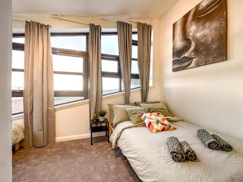 a bedroom with a bed and a large window at Sunny day new flat with 5 beds in Clydebank