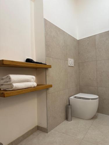 a bathroom with a white toilet and some towels at Sara Home in Guarene