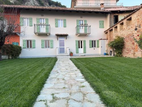 a house with a green lawn in front of it at Sara Home in Guarene