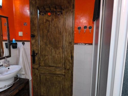 a bathroom with a wooden door and a sink at El Dúplex del Monumento in San Juan de Aznalfarache