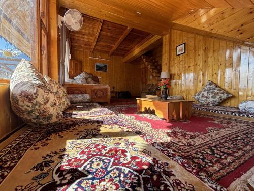 ein Wohnzimmer mit Sofa und Tisch in der Unterkunft Cafe Saffron Sips & Stays - Alpine Suites Naggar Near Manali in Nagar