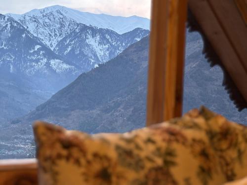 a view of a snowy mountain range from a window at Alpine suites in Nagar