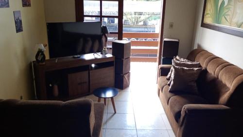 a living room with two couches and a flat screen tv at Hostel Maria Fumaça in Louro Müller