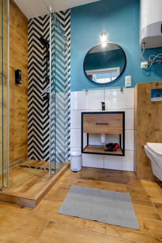 a bathroom with a fireplace and a mirror at Poddąbek Comfort I Apartamenty z tarasem na dachu, ogródkiem, basenem zewnętrznym i wewnętrznym, salą zabaw i animacjami in Poddąbie