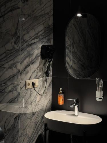 a bathroom with a sink and a mirror at The West Inn-Georgia Hotel in Kutaisi