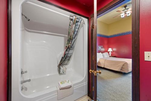 Un baño con bañera y un dormitorio. en Historic Iron Horse Inn - Deadwood, en Deadwood