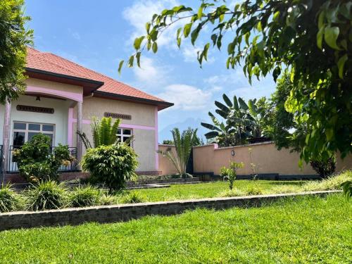 a house with a green lawn in front of it at Kinigi Holiday Home in Kinigi
