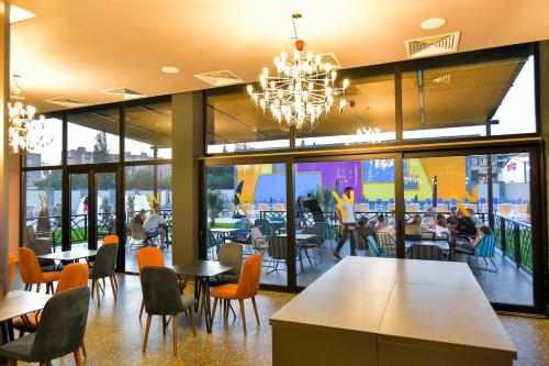 a restaurant with tables and chairs and a chandelier at The West Inn-Georgia Hotel in Kutaisi