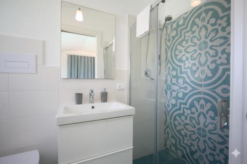 Un baño blanco con lavabo y ducha en Villa Verde Essence, en Castellammare del Golfo